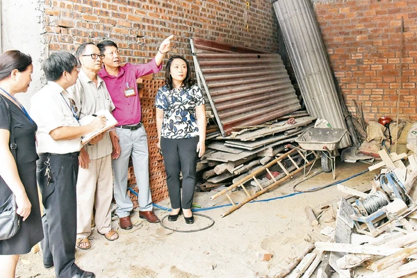 Cán bộ Phòng Lao động - Thương binh và Xã hội quận Ðống Ða kiểm tra công trình xây dựng nhà cho người có công tại phường Cát Linh. Ảnh: Ðăng Anh