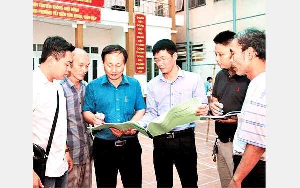 Cán bộ MTTQ phường Yết Kiêu, quận Hà Đông (Hà Nội) trao đổi, giám sát công việc cải tạo một công trình văn hóa. Ảnh: BÁ HOẠT