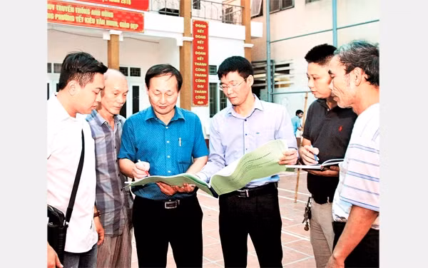 Cán bộ MTTQ phường Yết Kiêu, quận Hà Đông (Hà Nội) trao đổi, giám sát công việc cải tạo một công trình văn hóa. Ảnh: BÁ HOẠT