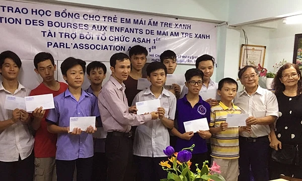 Ông Nguyễn Thanh Tòng (thứ 2, phải sang) trao học bổng cho trẻ em tại Trung tâm Mái ấm Tre xanh ở TP Hồ Chí Minh.