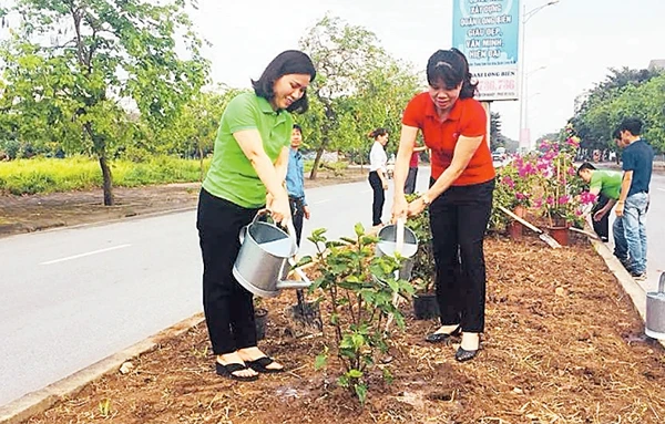 Hội viên Hội Liên hiệp Phụ nữ và Ðoàn Thanh niên quận Long Biên tham gia làm đẹp môi trường.