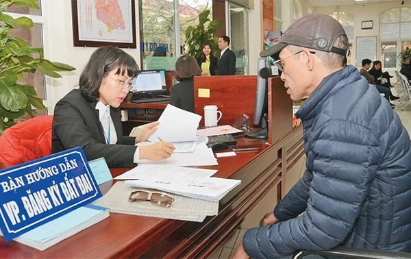 Cán bộ bộ phận "một cửa" UBND quận Nam Từ Liêm hướng dẫn người dân đến làm thủ tục hành chính.