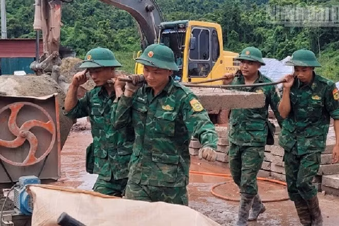 Cán bộ, chiến sĩ Bộ đội Biên phòng Điện Biên chung sức vận chuyển vật liệu phục vụ thi công xây dựng Trường nội trú liên cấp Sín Thầu. 
