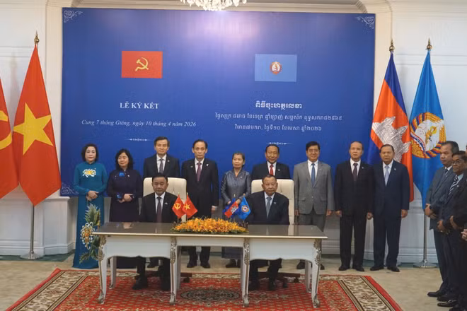Thường trực Ban Bí thư Trần Cẩm Tú và Phó Chủ tịch Đảng Nhân dân Campuchia, Trưởng Ban Thường trực Ban Thường vụ Đảng Nhân dân Campuchia Say Chhum chứng kiến lễ trao các văn kiện hợp tác. (Ảnh: ĐINH TRƯỜNG) 