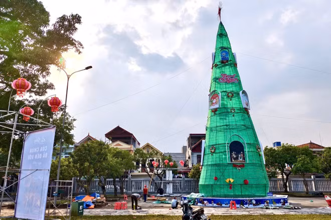 Giáo dân trang hoàng cây thông chào đón Giáng sinh tại Nhà thờ Phát Diệm, góp phần thu hút du khách. (Ảnh: VĂN LÚA)