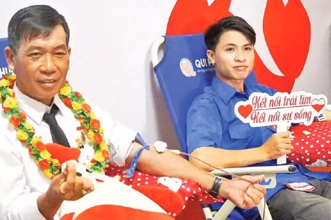 Ông Trần Minh Mến (bên trái) tham gia hiến máu tình nguyện. (Ảnh: Lê Minh)