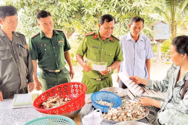 Trung tá Châu Văn Nát cùng đại diện Bộ đội Biên phòng và thành viên Đội dân phòng cơ động đến nhà dân tuyên truyền phòng chống lừa đảo trực tuyến.