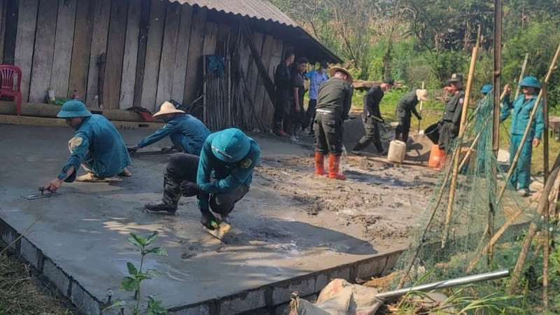Công an và dân quân tự vệ hỗ trợ đổ bê tông nền nhà cho hộ nghèo ở xã Hiệp Lực. (Ảnh: THÀNH TÂM)