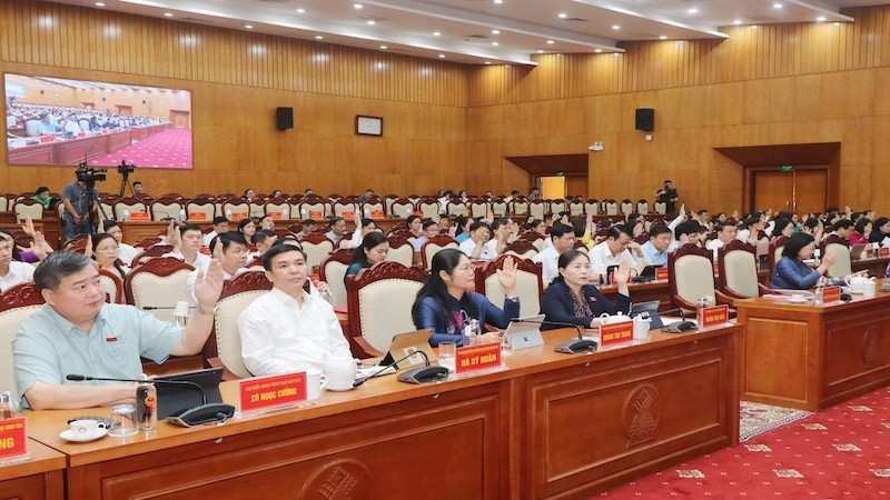 Các đại biểu biểu quyết thông qua nghị quyết. (Ảnh: TUẤN SƠN)