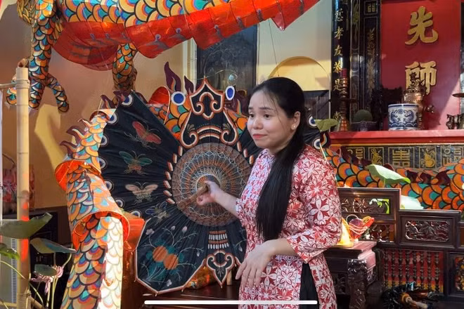 Chị Nguyễn Minh Nguyệt, thuyết minh cho khách tham quan về quá trình phục dựng lồng đèn xưa.