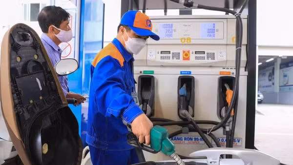 Nhân viên bơm xăng cho khách hàng tại một cửa hàng kinh doanh xăng dầu. (Ảnh: THÀNH ĐẠT)