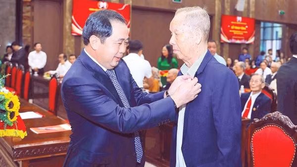 Bí thư Thành ủy Trần Đức Thắng gắn Huy hiệu Đảng tặng đảng viên lão thành (Ảnh THÁI QUANG)