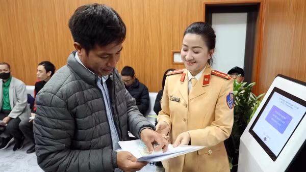 Cán bộ Đội sát hạch, cấp giấy phép lái xe cơ giới đường bộ (Phòng Cảnh sát giao thông, Công an thành phố Hà Nội) hướng dẫn người dân thực hiện thủ tục hành chính. (Ảnh: Thanh Hà)
