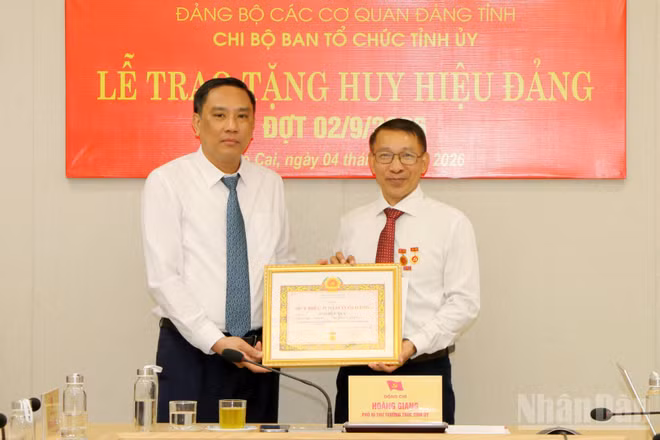 Phó Bí thư Thường trực Tỉnh ủy, Chủ tịch Hội đồng nhân dân tỉnh Lào Cai Hoàng Giang trao Huy hiệu 35 năm tuổi Đảng cho đồng chí Ngô Hữu Quý. (Ảnh: TÂM THỜI)