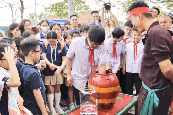 Học sinh thử tài bắt chạch trong chum tại phường rối Đào Thục, xã Thư Lâm, Hà Nội.