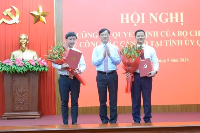 Đồng chí Nguyễn Duy Ngọc, Ủy viên Bộ Chính trị, Bí thư Trung ương Đảng, Trưởng Ban Tổ chức Trung ương trao quyết định và tặng hoa chúc mừng 2 đồng chí Vương Quốc Tuấn (bên phải) và Bùi Hoàng Phương. (Ảnh: HG)