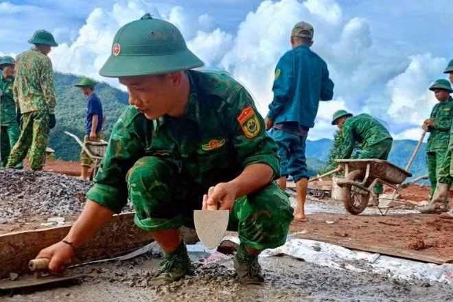 Chiến sĩ Ban Chỉ huy Bộ đội Biên phòng tỉnh Điện Biên giúp người dân bản Háng Pù Xi, xã Xa Dung làm nhà ở mới sau lũ quét