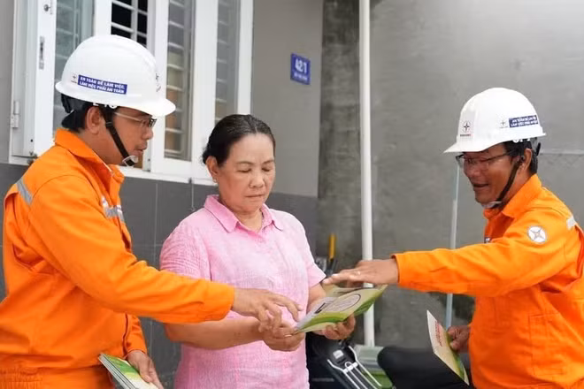 Nhân viên Công ty Điện lực Đất Đỏ trực tiếp tuyên truyền, hướng dẫn người dân các biện pháp sử dụng điện an toàn trong mùa mưa bão. (Ảnh: DUY ĐOÀN)