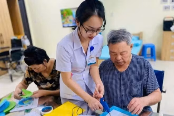 Nhân viên y tế hỗ trợ người cao tuổi phục hồi chức năng tại Trung tâm chăm sóc sức khỏe người cao tuổi Đà Nẵng. (Ảnh ST)