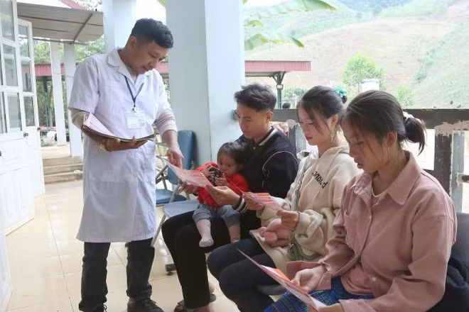 Cán bộ Trạm Y tế Tân Xuân, xã Xuân Nha, tỉnh Sơn La, phát tờ rơi tuyên truyền về giảm thiểu mất cân bằng giới tính khi sinh.