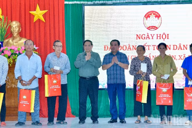 Thủ tướng Phạm Minh Chính tặng quà các hộ dân ở khu dân cư Thắng Kiên, xã Đề Gi, nhân Ngày hội Đại đoàn kết toàn dân tộc. (Ảnh: THANH GIANG)