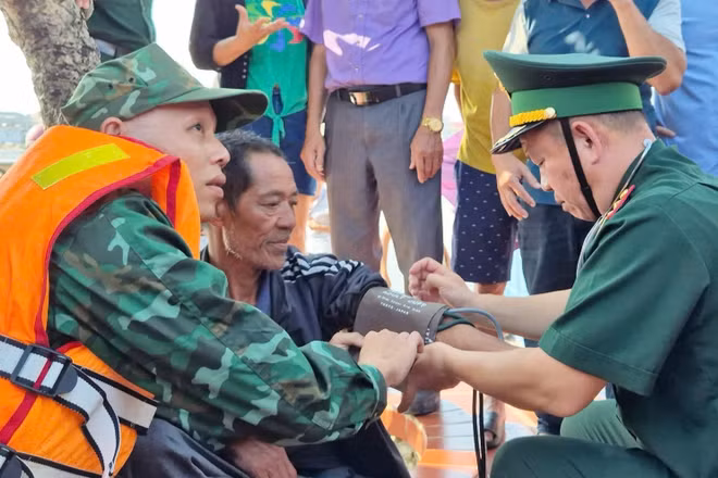 Quân y Đồn Biên phòng Lý Hòa kiểm tra sức khỏe cho ngư dân Nguyễn Tiến Châu khi vừa được tàu cá Quảng Bình cứu nạn đưa vào bờ. (Ảnh: HN)