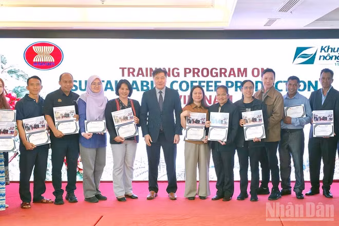 Giám đốc Trung tâm Khuyến nông quốc gia Lê Quốc Thanh trao chứng nhận và ảnh lưu niệm cho các học viên tham gia lớp tập huấn. (Ảnh: BẢO VĂN)