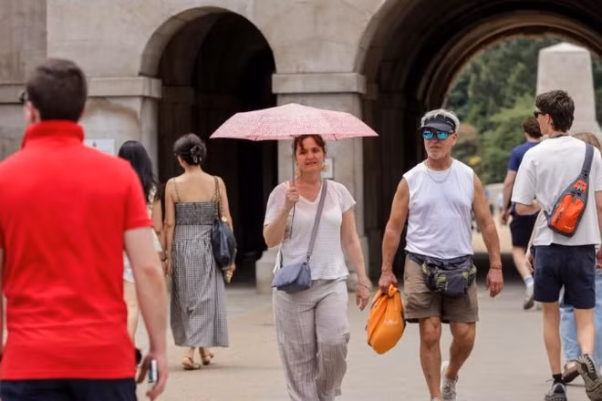 Một người phụ nữ che ô tránh nắng trong đợt nắng nóng tiếp diễn ở London, Anh, ngày 1/7/2025. (Ảnh minh họa: TÂN HOA XÃ)