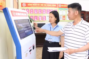 Công chức Trung tâm Phục vụ hành chính công xã Kim Thành, thành phố Hải Phòng, hướng dẫn người dân làm thủ tục hành chính. (Ảnh: TTXVN) 