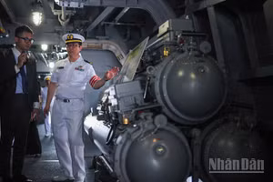 Sĩ quan tàu giới thiệu cụm bệ phóng ngư lôi chống ngầm trên tàu hộ vệ Asahi của lực lượng tự vệ trên biển Nhật Bản.