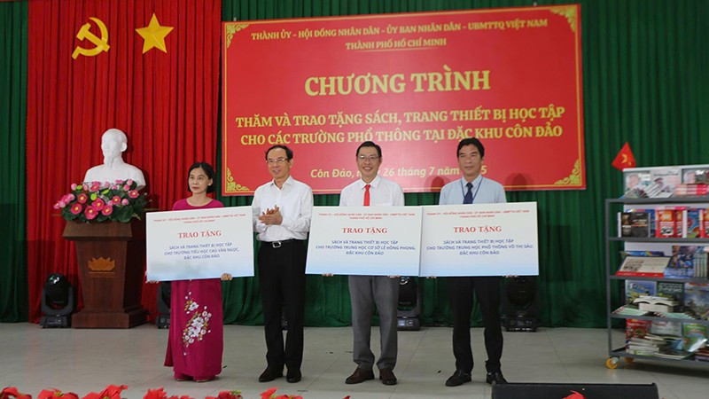 Đồng chí Nguyễn Văn Nên, Ủy viên Bộ Chính trị, Bí thư Thành ủy Thành phố Hồ Chí Minh trao bảng tượng trưng tặng sách và thiết bị học tập cho 3 trường tại Côn Đảo (Ảnh Ban tổ chức).