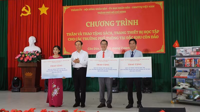Đồng chí Nguyễn Văn Nên, Ủy viên Bộ Chính trị, Bí thư Thành ủy Thành phố Hồ Chí Minh trao bảng tượng trưng tặng sách và thiết bị học tập cho 3 trường tại Côn Đảo (Ảnh Ban tổ chức).