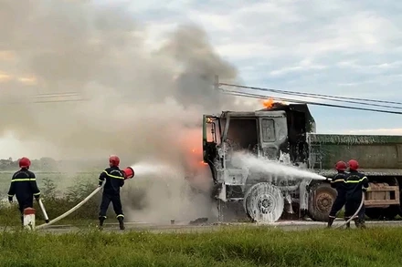 Lực lượng chuyên nghiệp sử dụng thiết bị chuyên dụng dập lửa khu vực cabin xe.