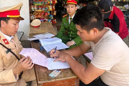 Công an lập biên bản vi phạm hành chính đối với người điều khiển ô-tô tải chở vật liệu, để đất rơi xuống đường.