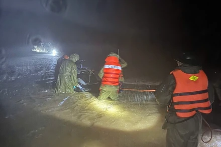 Lực lượng chức năng định vị, sử dụng mô-tô nước tiếp cận ngôi nhà bị lũ cô lập.