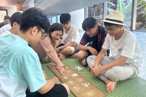 Các em nhỏ trải nghiệm trò chơi ô ăn quan. (Ảnh: Bảo tàng cung cấp)