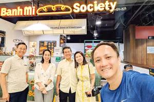 Chị Quỳnh (thứ hai, trái sang) tại tiệm bánh mì Việt Nam ở Singapore.