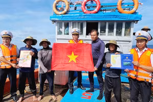 Tổ Bầu cử trao cờ Tổ quốc và quà cho các ngư dân tàu QNg 96435 TS, sau khi các ngư dân tàu hoàn thành bầu cử.