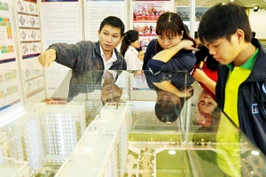 Khách hàng trẻ tìm hiểu căn hộ dành cho người thu nhập thấp tại sàn giao dịch. Ảnh: NGUYỆT ANH