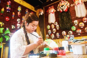 Huyền Trang vẽ mặt nạ tại không gian trưng bày và trải nghiệm của gia đình.