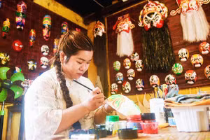 Huyền Trang vẽ mặt nạ tại không gian trưng bày và trải nghiệm của gia đình.