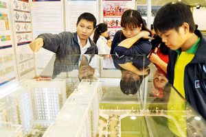 Khách hàng trẻ tìm hiểu căn hộ dành cho người thu nhập thấp tại sàn giao dịch. Ảnh: NGUYỆT ANH