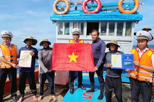 Tổ Bầu cử trao cờ Tổ quốc và quà cho các ngư dân tàu QNg 96435 TS, sau khi các ngư dân tàu hoàn thành bầu cử.