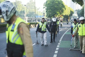 Các tình nguyện viên thu gom đinh trên đường phố Jakarta. Ảnh: AP