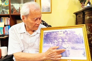 Ông La Văn Sàng bên tấm ảnh chụp cùng các chuyên gia Liên Xô.