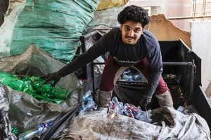 Mina đang phân loại chai lọ nhựa. Ảnh: THE GUARDIAN