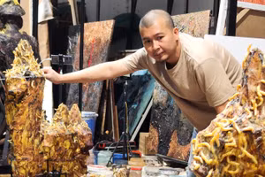 Lê Hữu Hiếu trong quá trình chuẩn bị cho tác phẩm. Anh cho tằm nhả tơ dệt trực tiếp trên bề mặt tác phẩm. (Ảnh: NVCC)