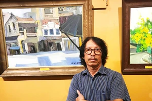 Họa sĩ Bùi Lê Dũng bên tác phẩm của mình.