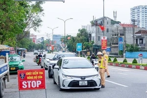 Cảnh sát giao thông Nghệ An kiểm tra nồng độ cồn đối với người điều khiển ô-tô. (Ảnh: Công an Nghệ An)