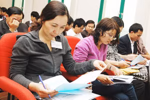 Cổ đông xem xét báo cáo tài chính của doanh nghiệp niêm yết. Ảnh: NAM ANH